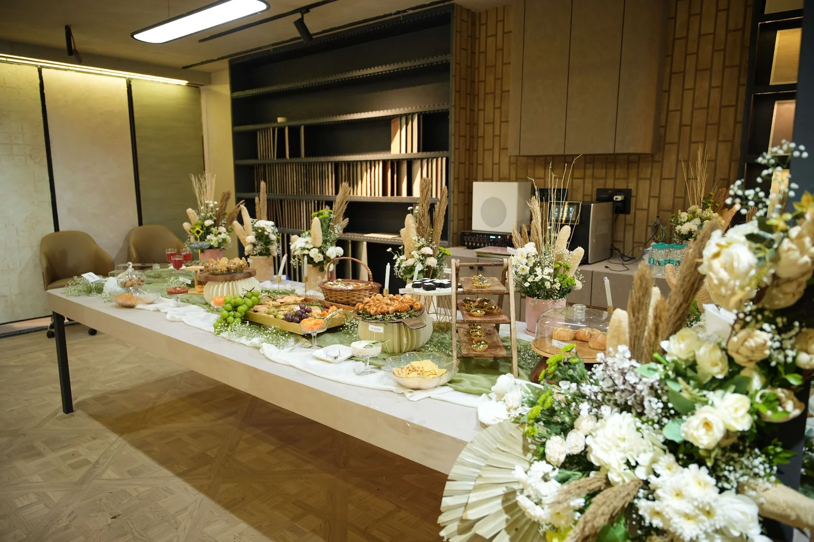An angled view along the grazing table, with white flowers and a variety of dishes.